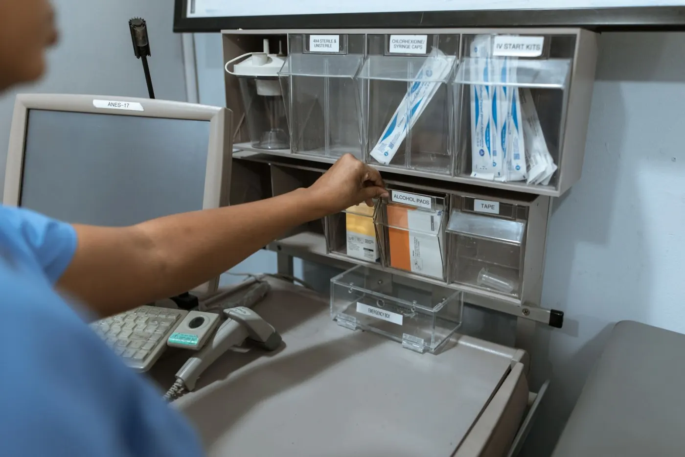 A nurse pulling supplies from labeled storage bins